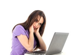 女性がパソコンを見ながら悩んでいる